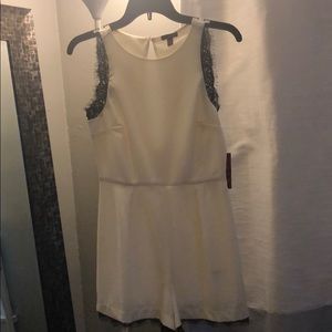 White romper with black lace trimming.